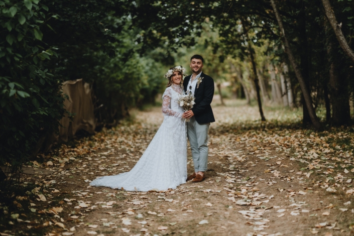 Bride and groom standing in forest path