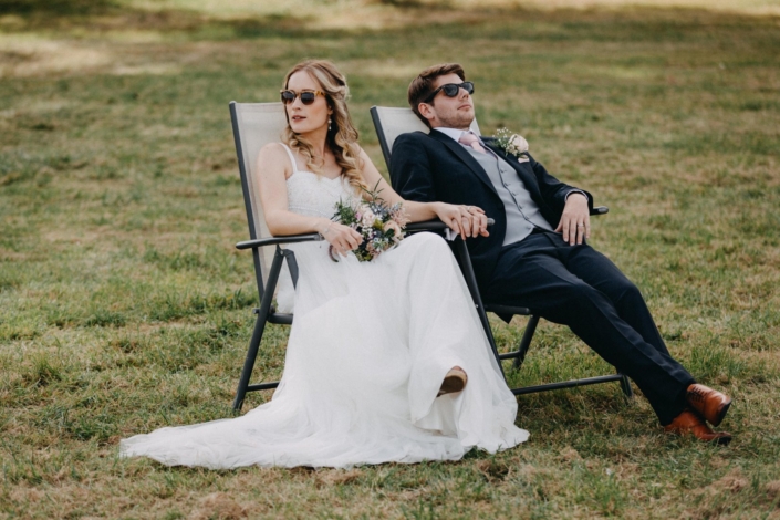 Bride and groom relaxing outdoors in sunglasses