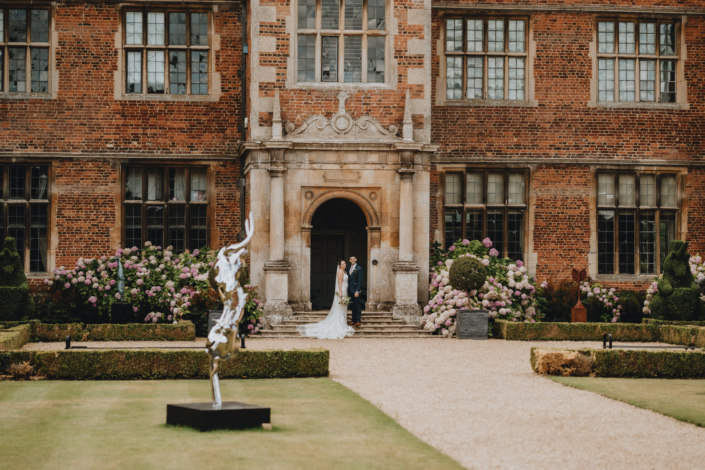 Historic building with couple in garden setting.