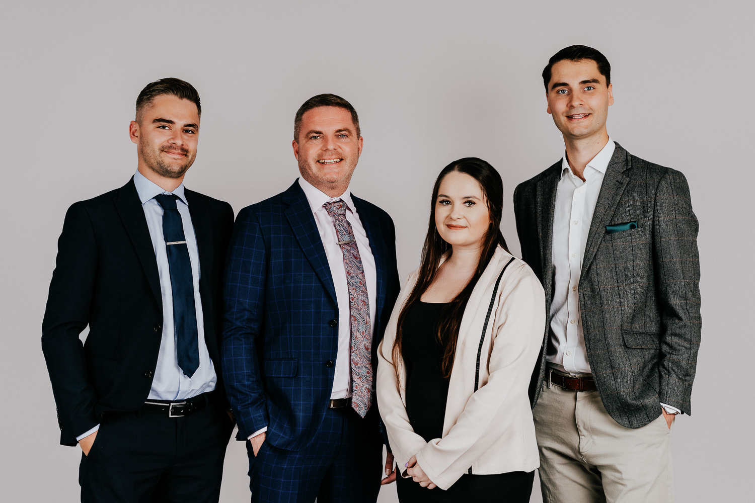 Four professionals posing in business attire together