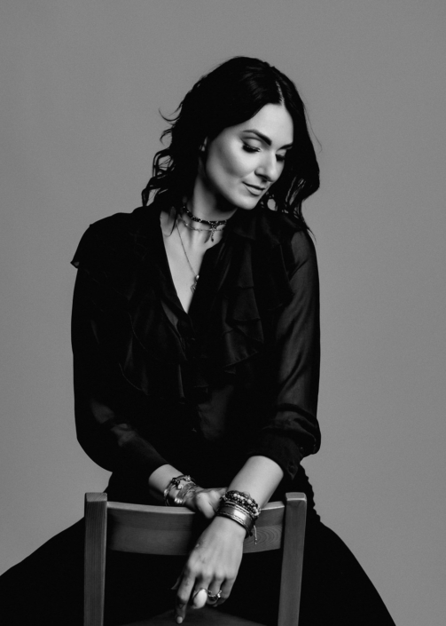 Woman sitting thoughtfully in stylish black attire