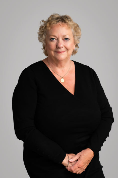 Smiling woman wearing black outfit and necklace