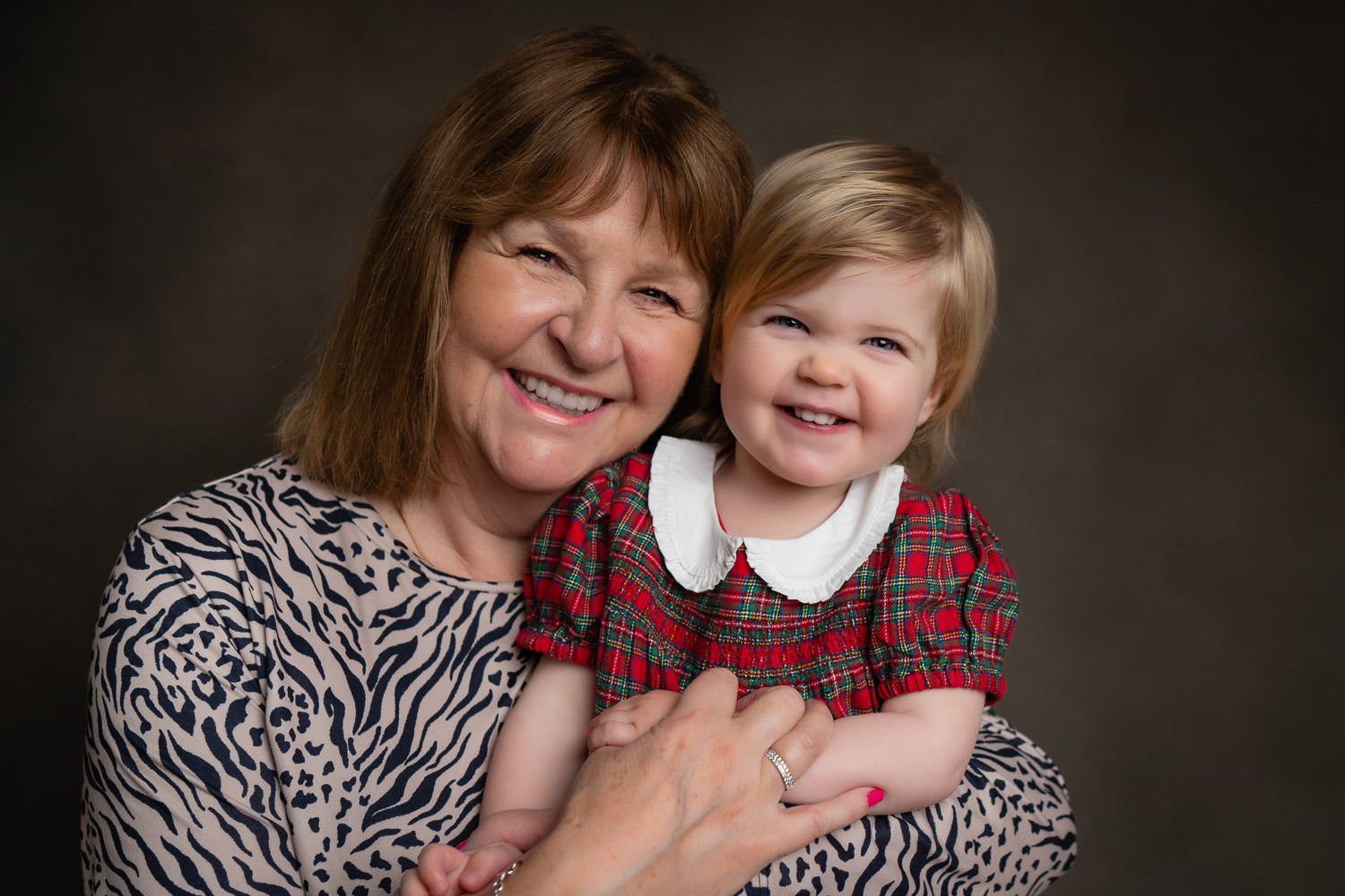 Grandmother and granddaughter smiling portrait together indoors