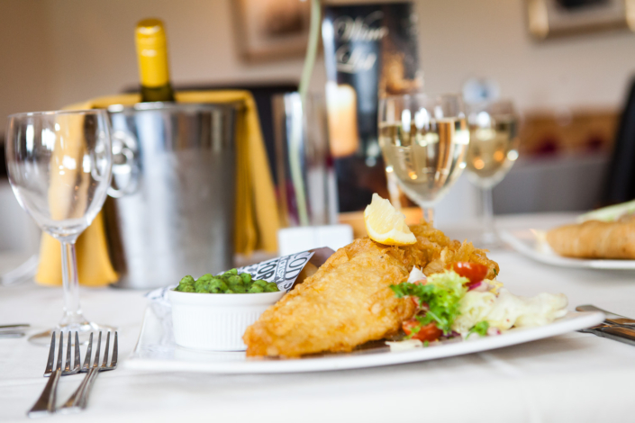 Fish and chips served with wine and salad