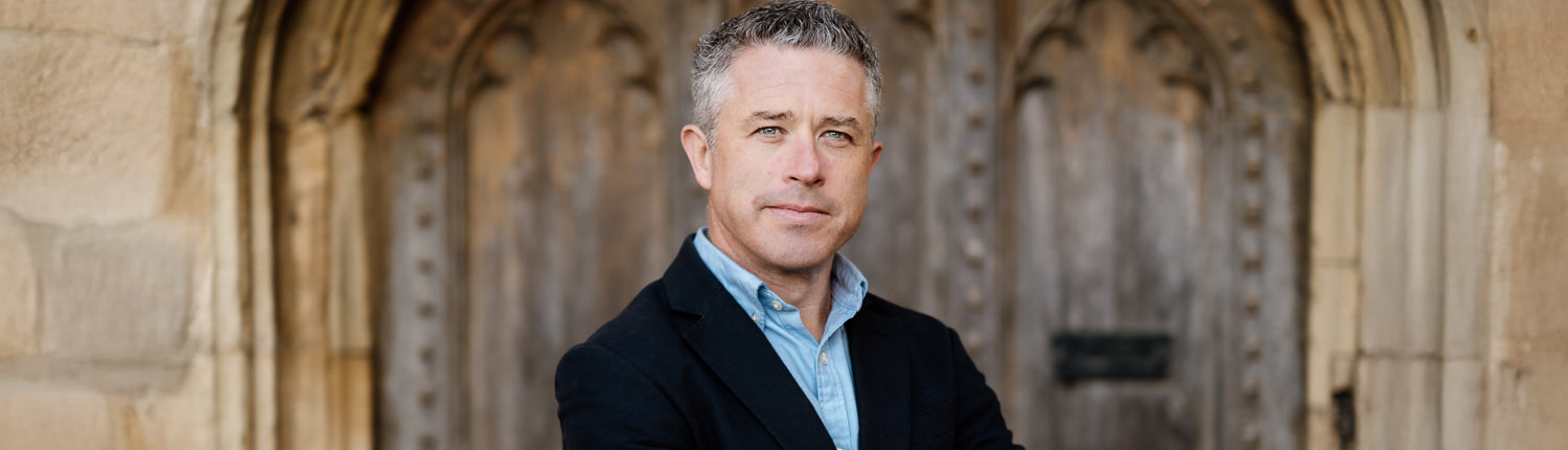 Man standing confidently in front of historic door