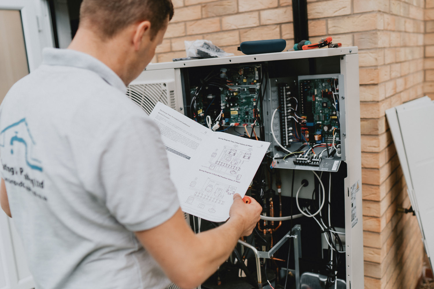 Electrician inspecting circuit board with manual guide
