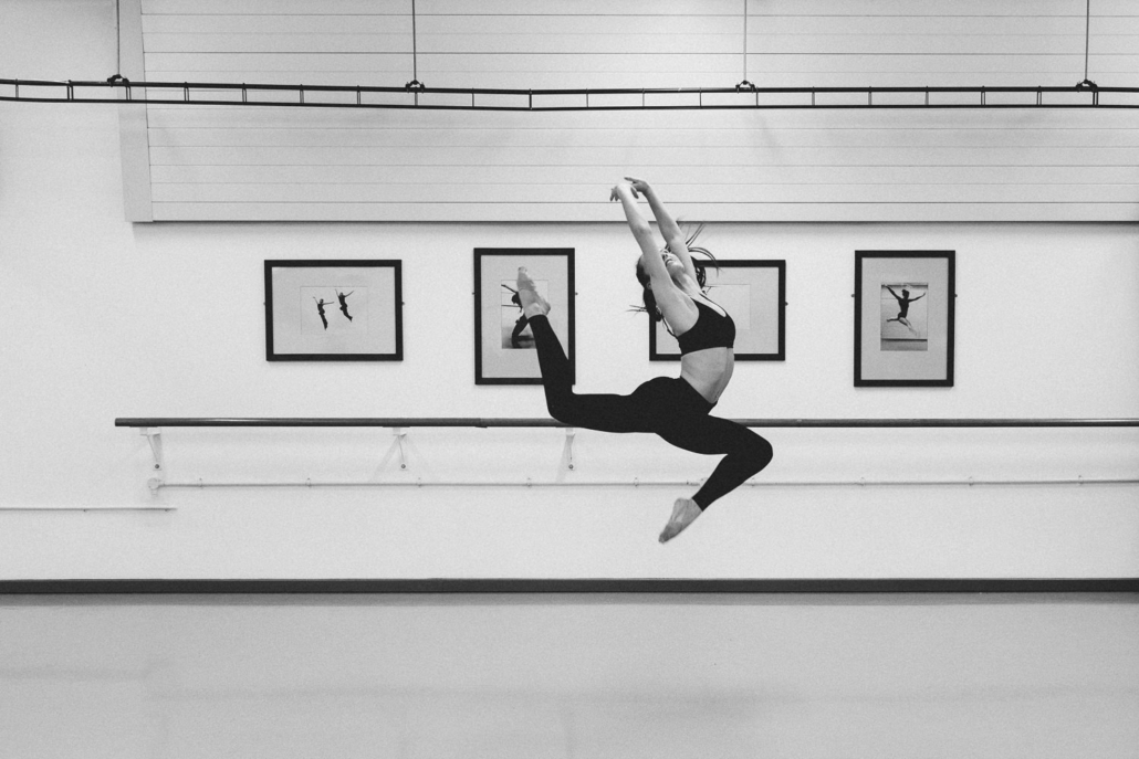 Dancer performing graceful jump in ballet studio