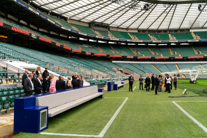 People touring an empty sports stadium field