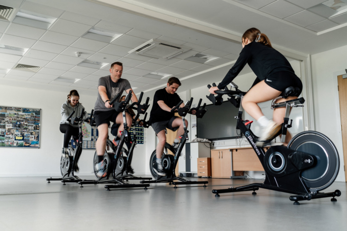 People exercising on stationary bikes in gym