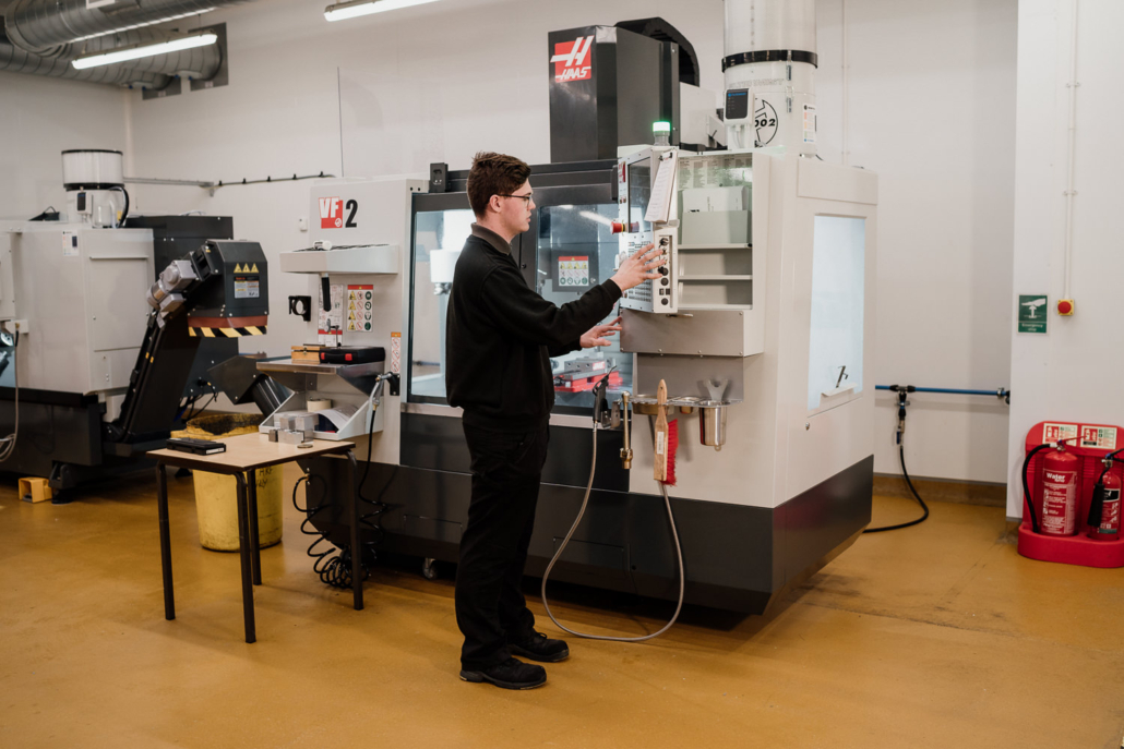 Technician operating advanced CNC machine in workshop