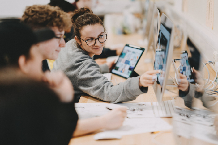 Students collaborating on a project using computers