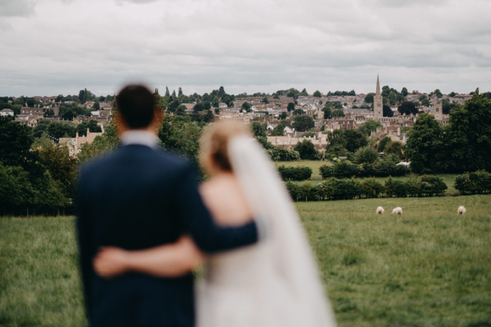 Couple overlooking countryside landscape on wedding day.