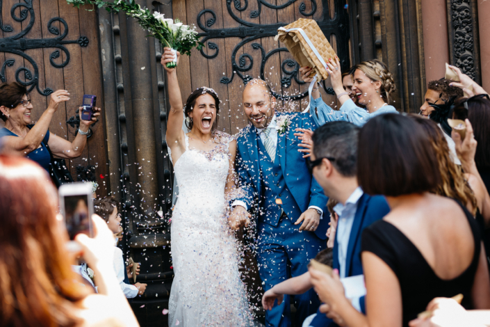Joyful wedding couple celebrating with guests outside